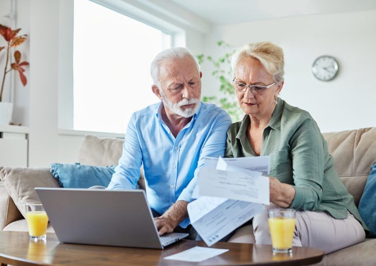 Senior,Couple,Checking,Bills,And,Calculating,Expenses,Using,A,Laptop